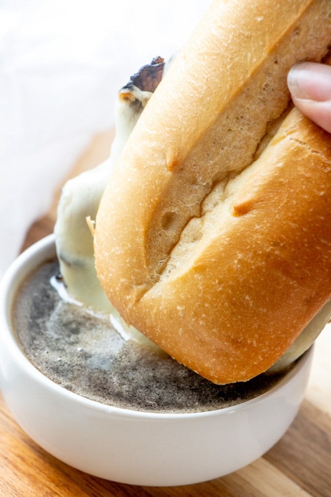 A French Dip Sandwich dipped into beef broth au jus.