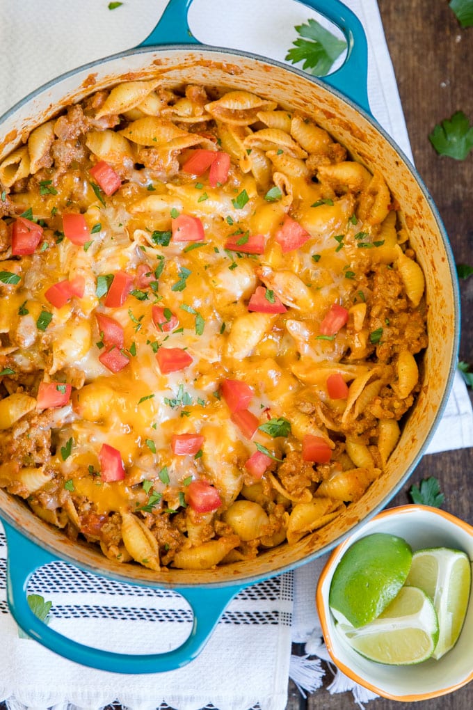 Ground Turkey Taco Pasta overhead in a blue pot with limes on the side.