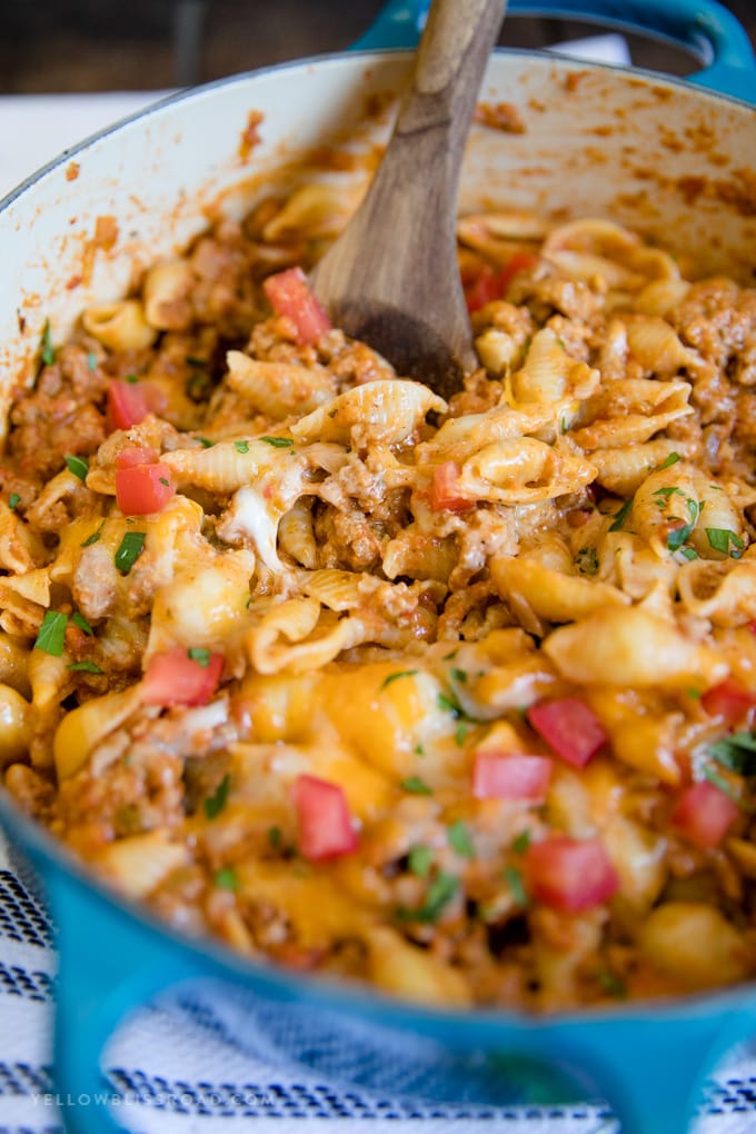 Ground Turkey Taco Pasta with a wooden spoon in a blue pot.