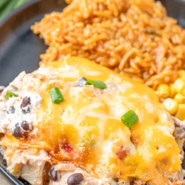 A plate filled with Mexican Chicken Casserole, rice, and corn.