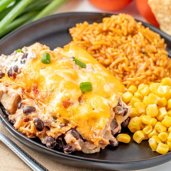 A plate filled with Mexican Chicken Casserole, rice, and corn.