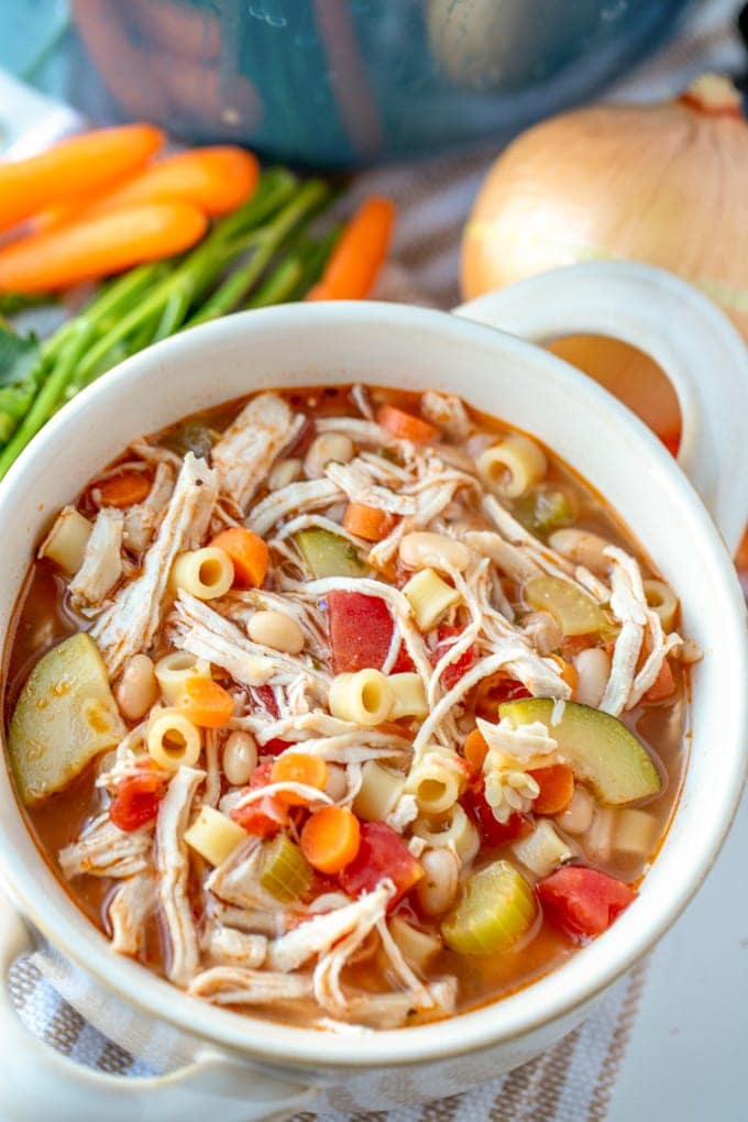 A large white bowl of chicken minestrone soup.