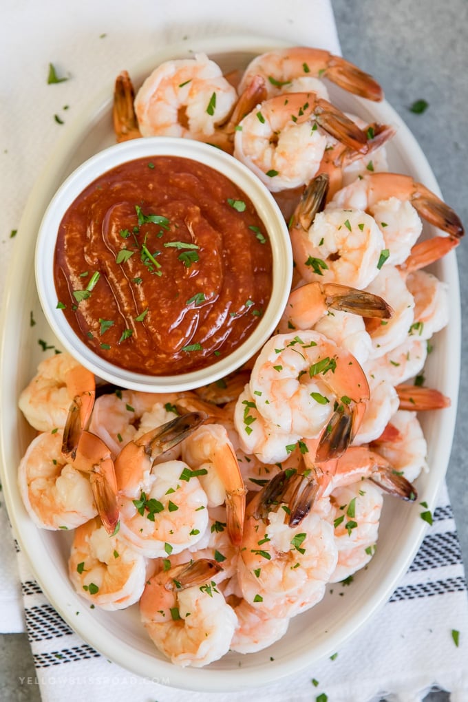 An overhead shot of a large platter of shrimp cocktail.