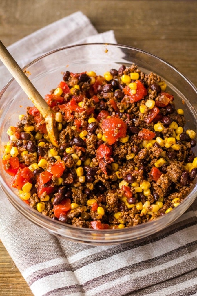 mexican lasagna beef filling ingredients mixed together in a bowl