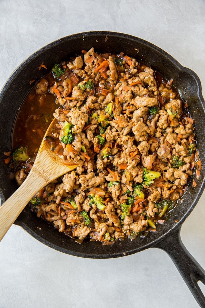 This Ground Turkey Recipe with Teriyaki Sauce and veggies on top of a big bowl of steamed rice makes these Teriyaki Turkey Rice Bowls a family favorite! Cooked ground turkey recipe in a skillet with vegetables and teriyaki sauce. Cast iron skillet.