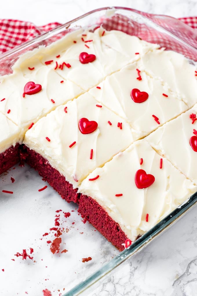 A pan of fudgy red velvet brownies topped with cream cheese icing. 