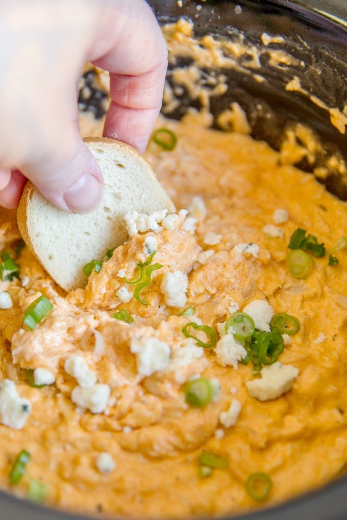 Bread dipped into slow cooker buffalo chicken dip
