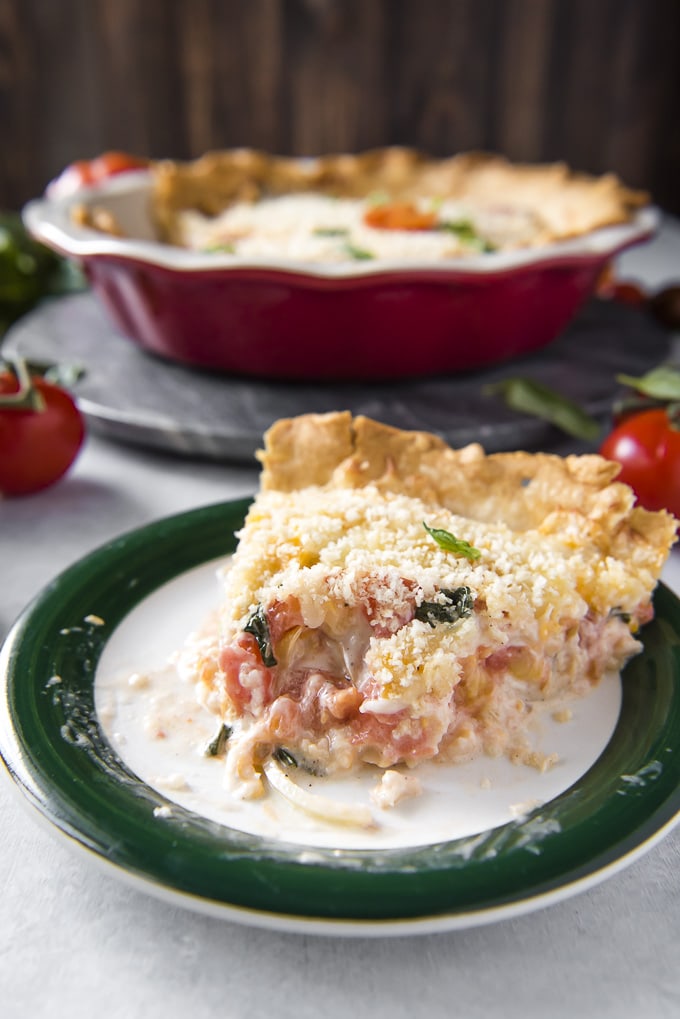 A slice of Tomato Pie on a plate with a bite take out of it.