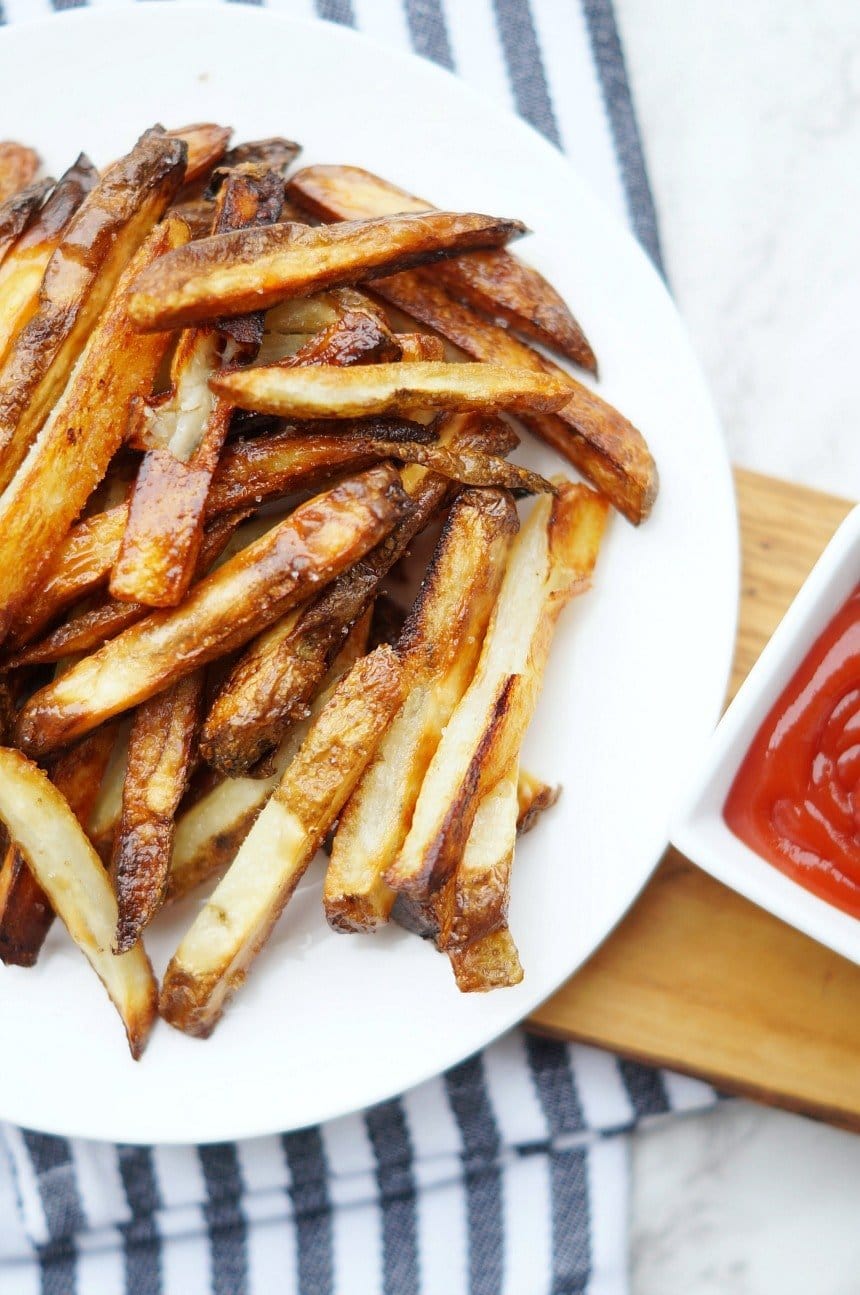 An overhead photo of baked homemade french fries with ketchup.
