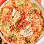 A pan filled with pasta and Bruschetta topped Chicken