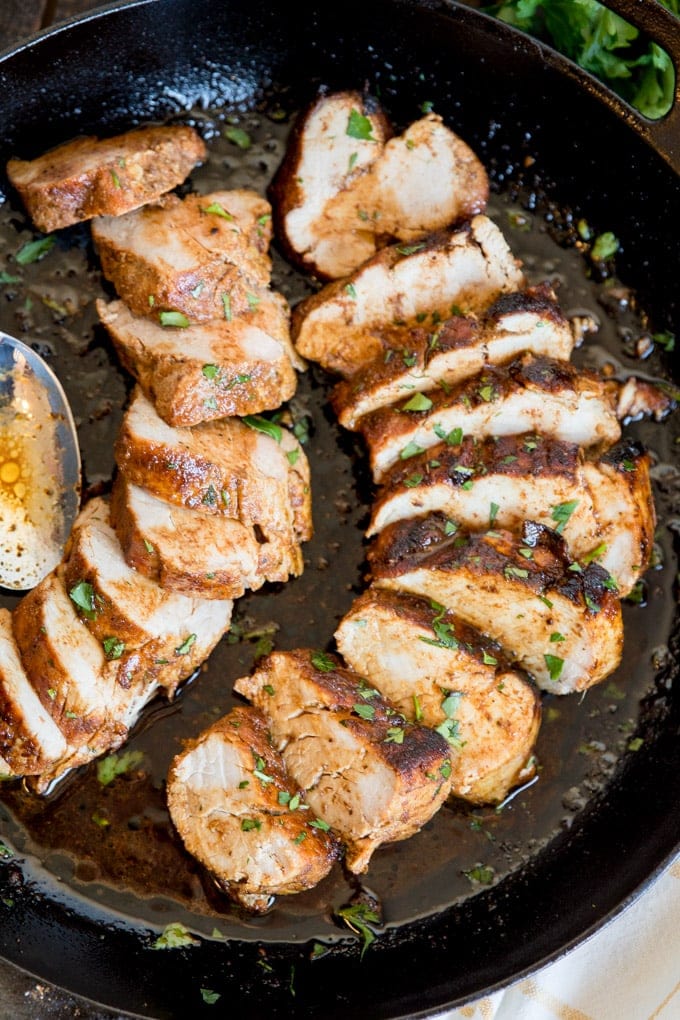 Sliced pork tenderloins in a cast iron skillet