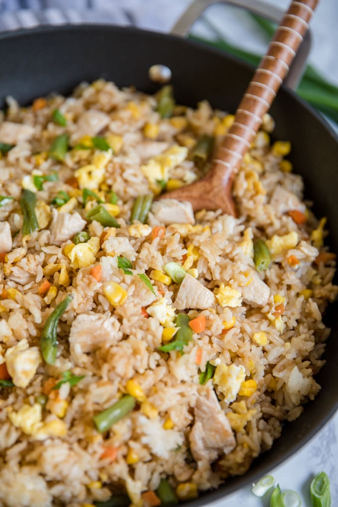 Homemade Easy Chicken Fried Rice is simple, and so much better than take-out! This simple dinner is made with just a few ingredients and packed with flavor! close up of chicken fried rice in a skillet