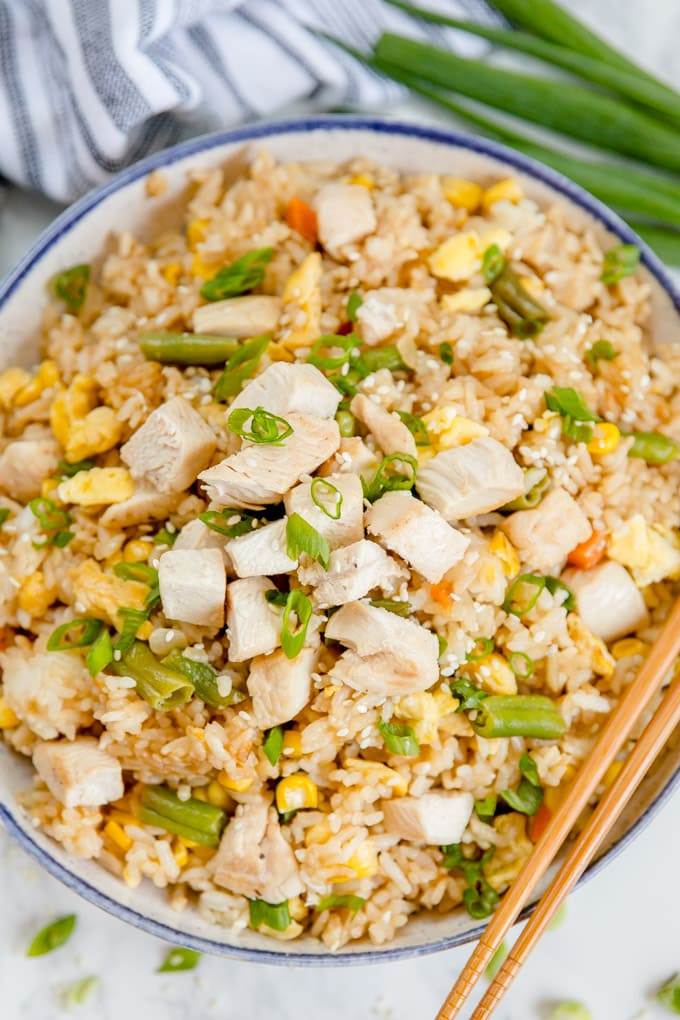 Overhead shot of chicken fried rice in a bowl with chopsticks