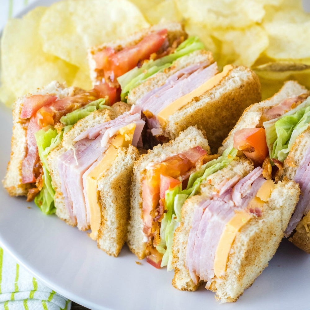 A club sandwich on a plate with chips