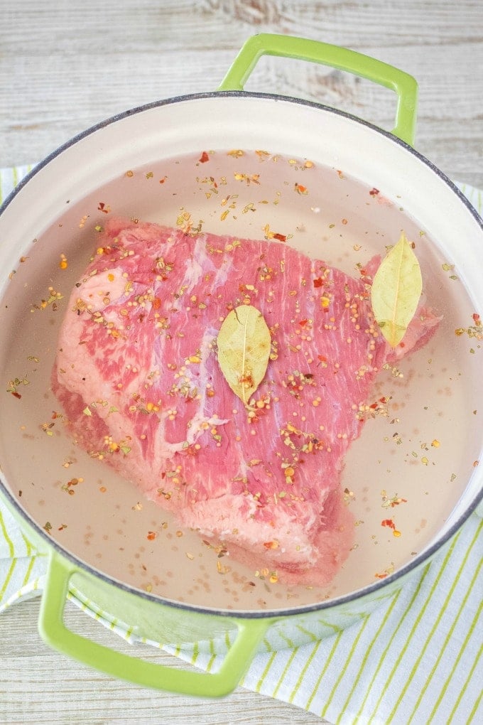 corned beef in a dutch oven with water and spices