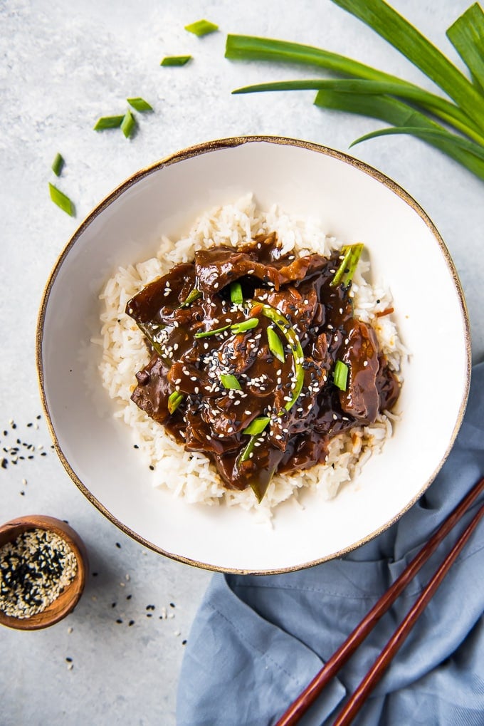 When you're in the mood for a delicious homemade version of your favorite Chinese takeout, this Slow Cooker Mongolian Beef is the answer! Slow Cooker Mongolian Beef in a bowl on a bed of rice