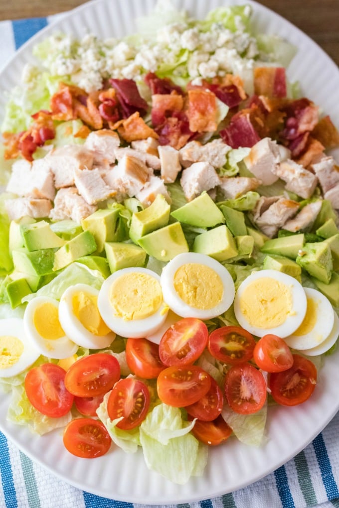 classic cobb salad with toppings lined up on top of lettuce