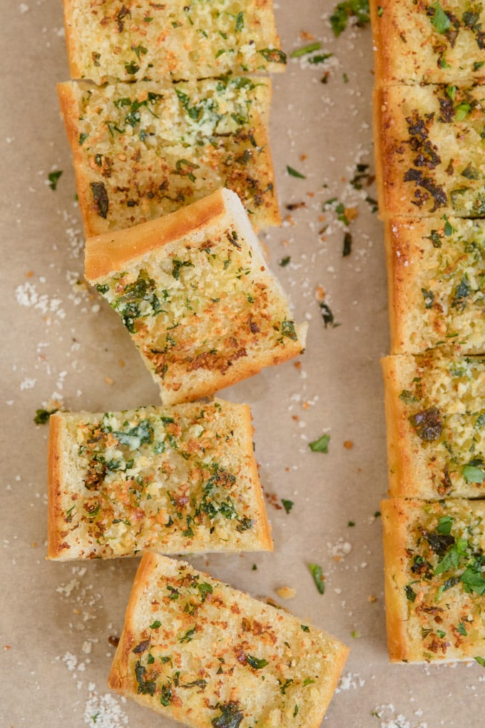 Round out any meal with this homemade Garlic Bread recipe, with homemade garlic butter and Parmesan cheese. This is how to make garlic bread the easy way. Sliced garlic bread from overhead