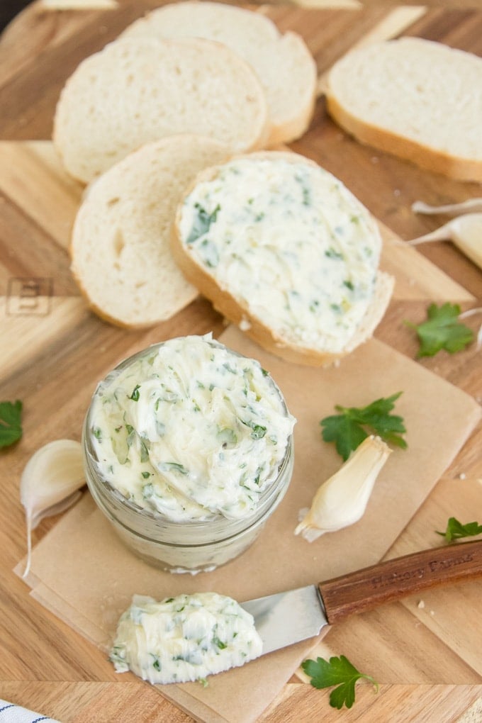 homemade garlic butter in a glass jar with some spread on bread