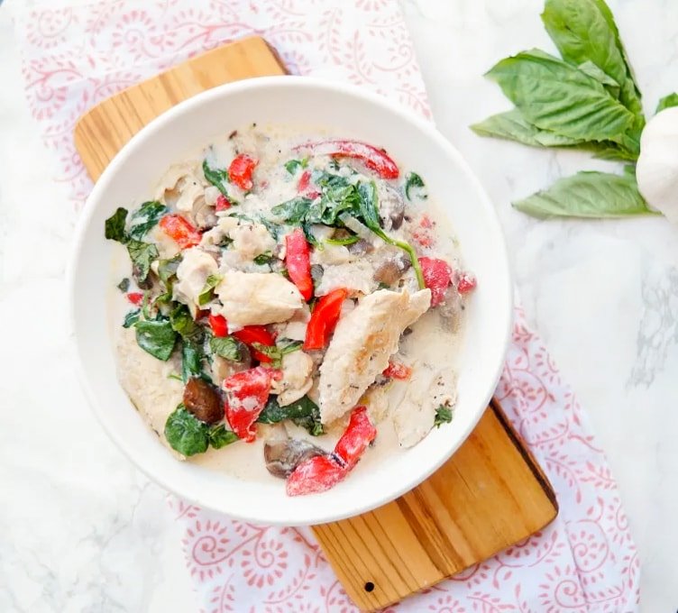 Instant Pot Chicken Florentine in a bowl sitting on a wood plank