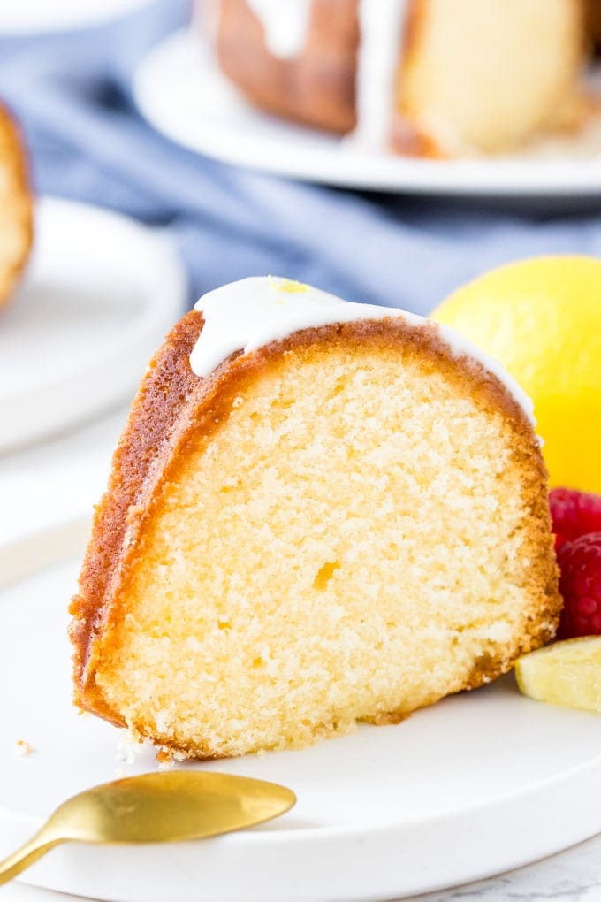 A slice of lemon pound cake with lemon glaze on a white plate. 