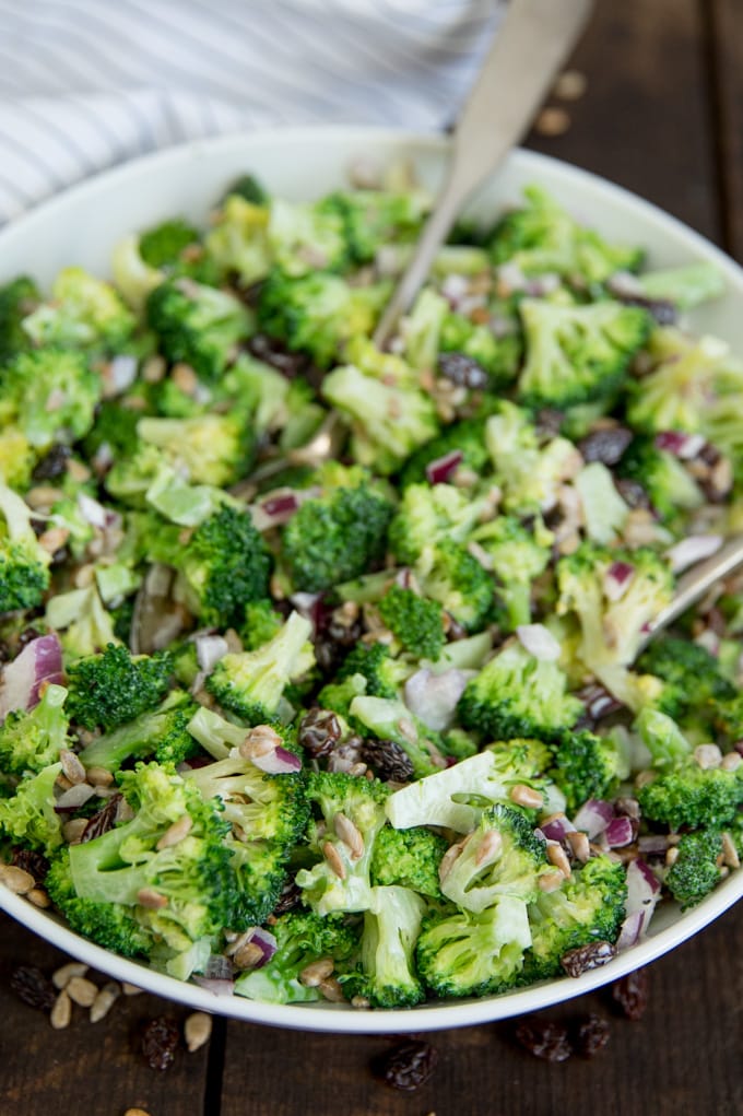 Broccoli Salad in a white bowl with spoons.
