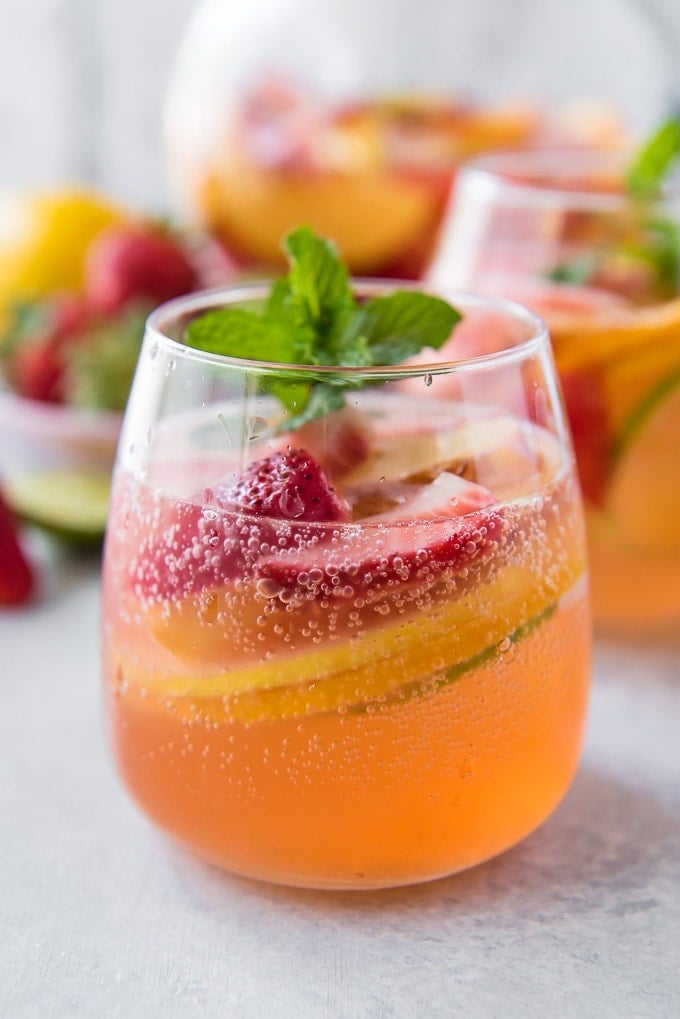 A close up of a glass of bubbling white sangria 