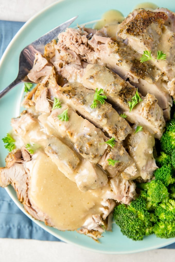 Crock Pot Pork Roast on a ble platter with gravy