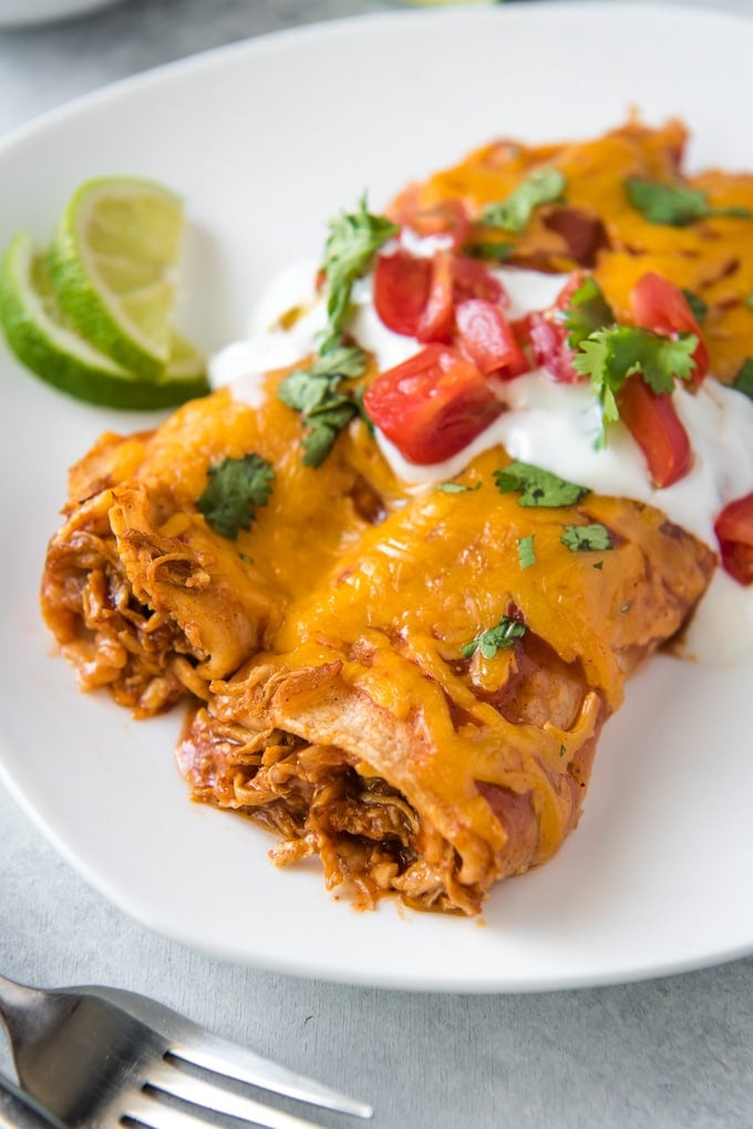 Chicken Enchiladas with sour cream and tomatoes on top