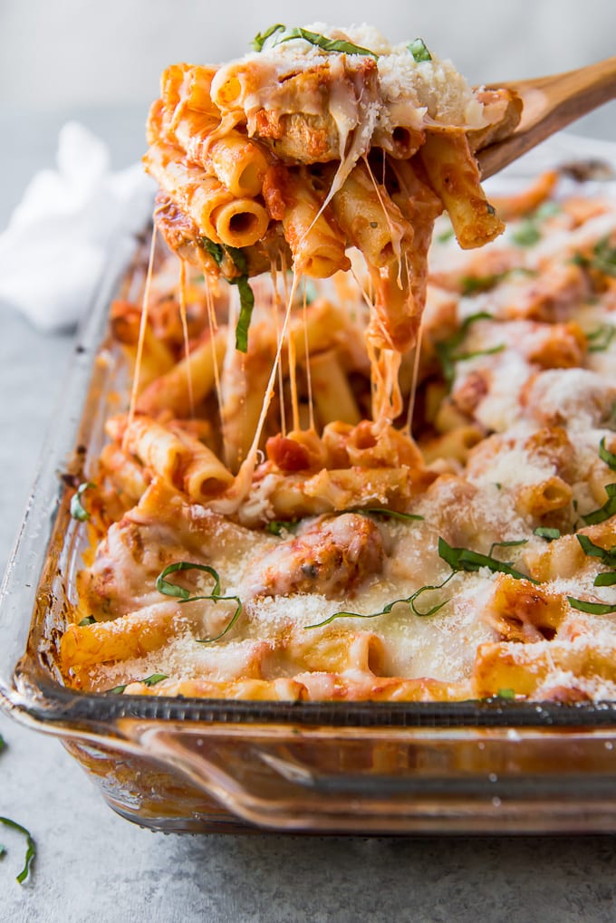 A serving of Chicken Parm Baked Ziti being lifted out of a casserole dish