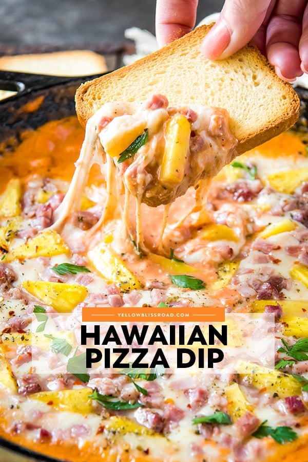 A piece of toast dipped into hawaiian pizza dip with ham and pineapple