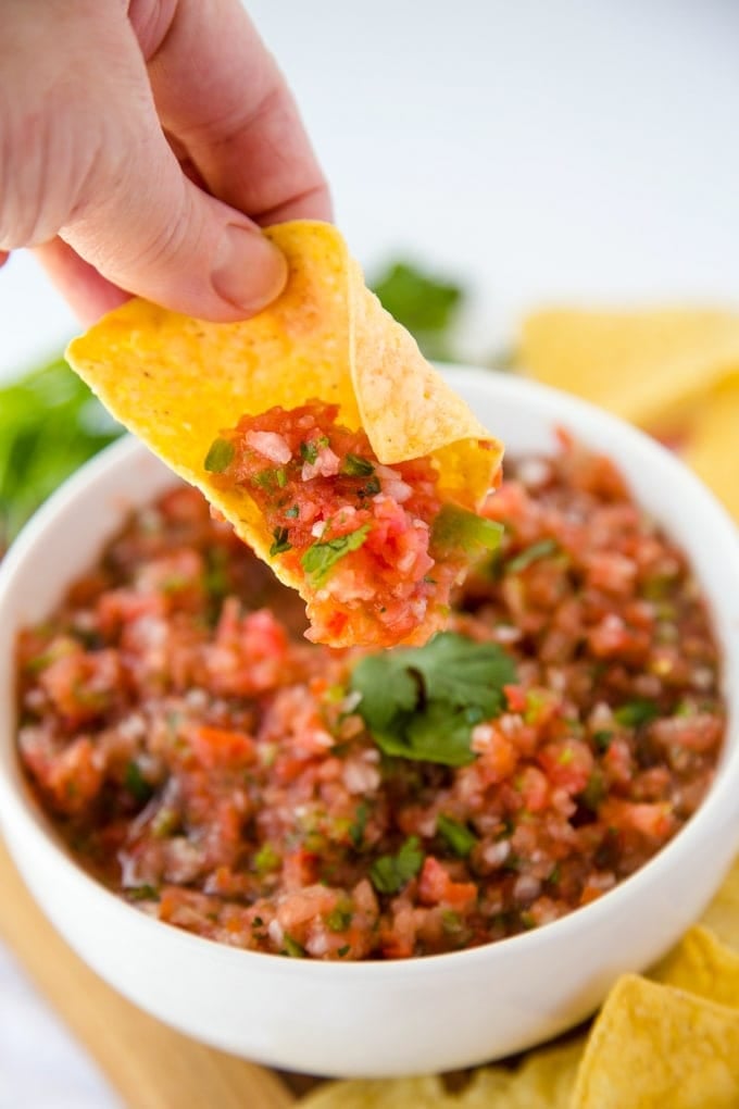 A tortilla chip dipped into fresh homemade salsa