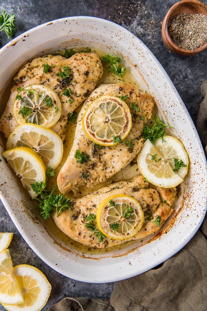 An overhead shot of lemon pepper chicken in a white casserole dish