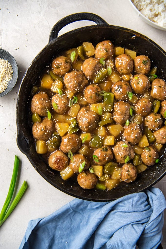 Sweet & Sour Meatballs with turkey meatballs, pineapple and bell peppers, all coated in a homemade sweet and tangy sauce. A great appetizer or main course. An overhead shot of a skillet with turkey meatballs in a sweet and sour sauce.