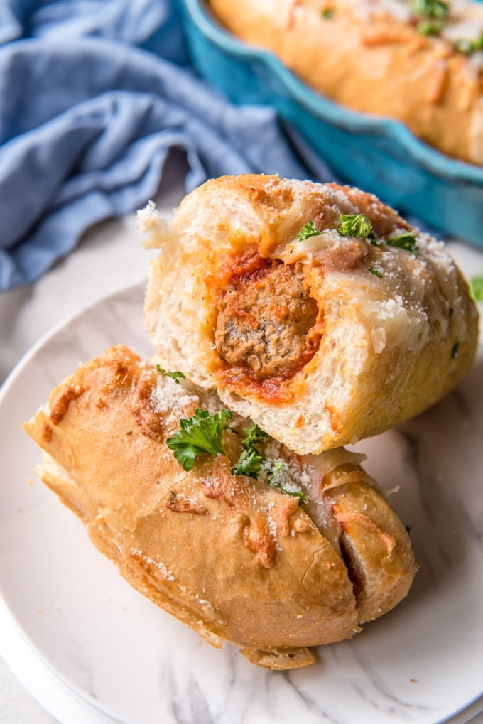 Turkey Meatball Subs are an easy weeknight dinner option that can also be made to feed a crowd. Meatballs, marinara sauce and cheese all stuffed inside a soft roll and baked until golden. A MEaball sub cut in half and stacked on a plate.