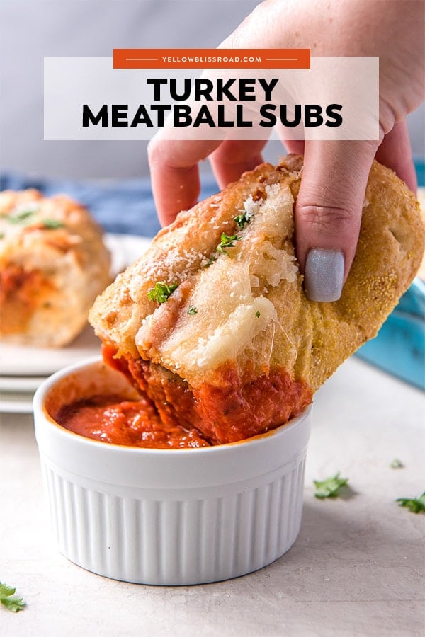 Turkey Meatball Subs are an easy weeknight dinner option that can also be made to feed a crowd. Meatballs, marinara sauce and cheese all stuffed inside a soft roll and baked until golden. Turkey Meatball Sub Sandwich dipped into marinara sauce with title text overlay