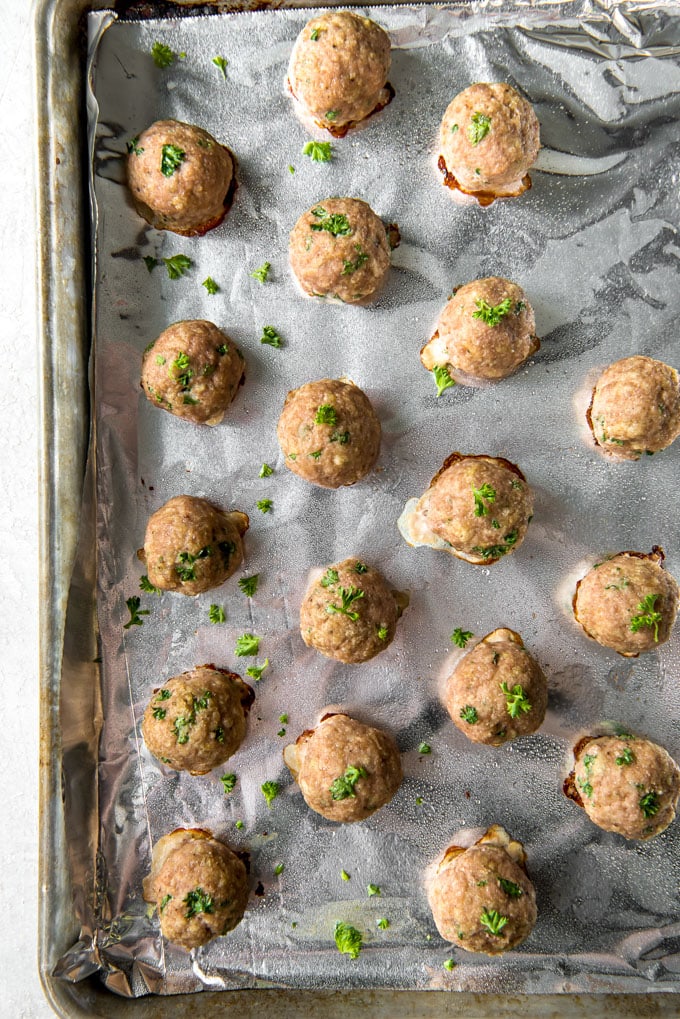 A cookie sheet with cooked turkey meatballs