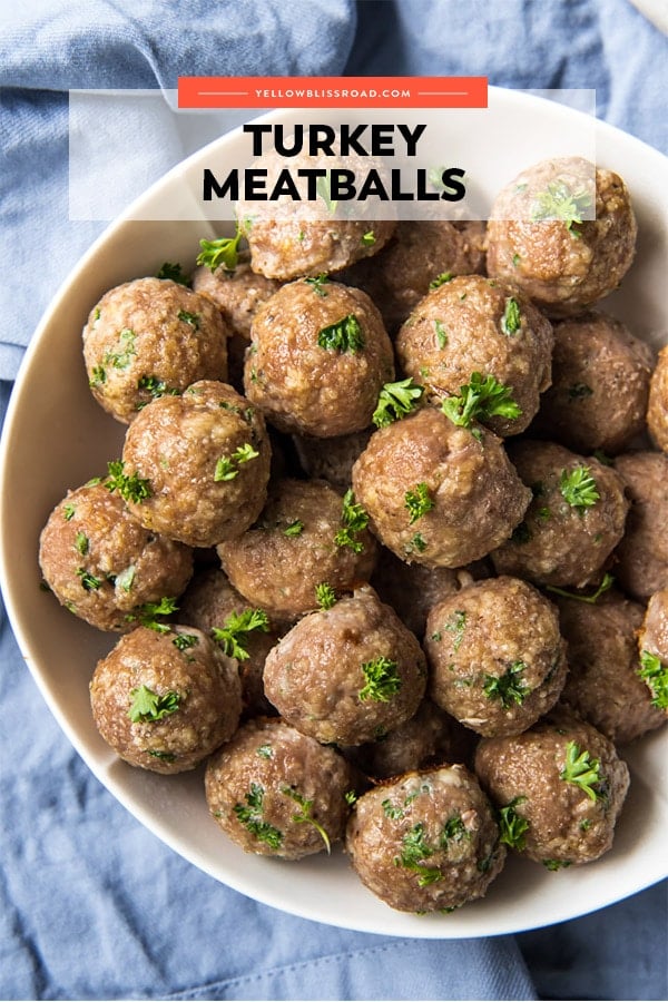 These Ground Turkey Meatballs are tender and moist and a great way to eat healthier without sacrificing flavor! Add them to soups, sandwiches and more! Ground Turkey Meatballs in a bowl with title of the recipe