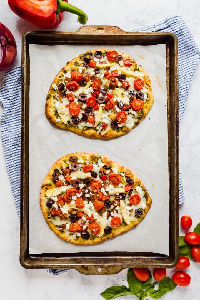 päällimmäinen kuva pannusta, jossa on kaksi kokonaista flatbread-pizzaa