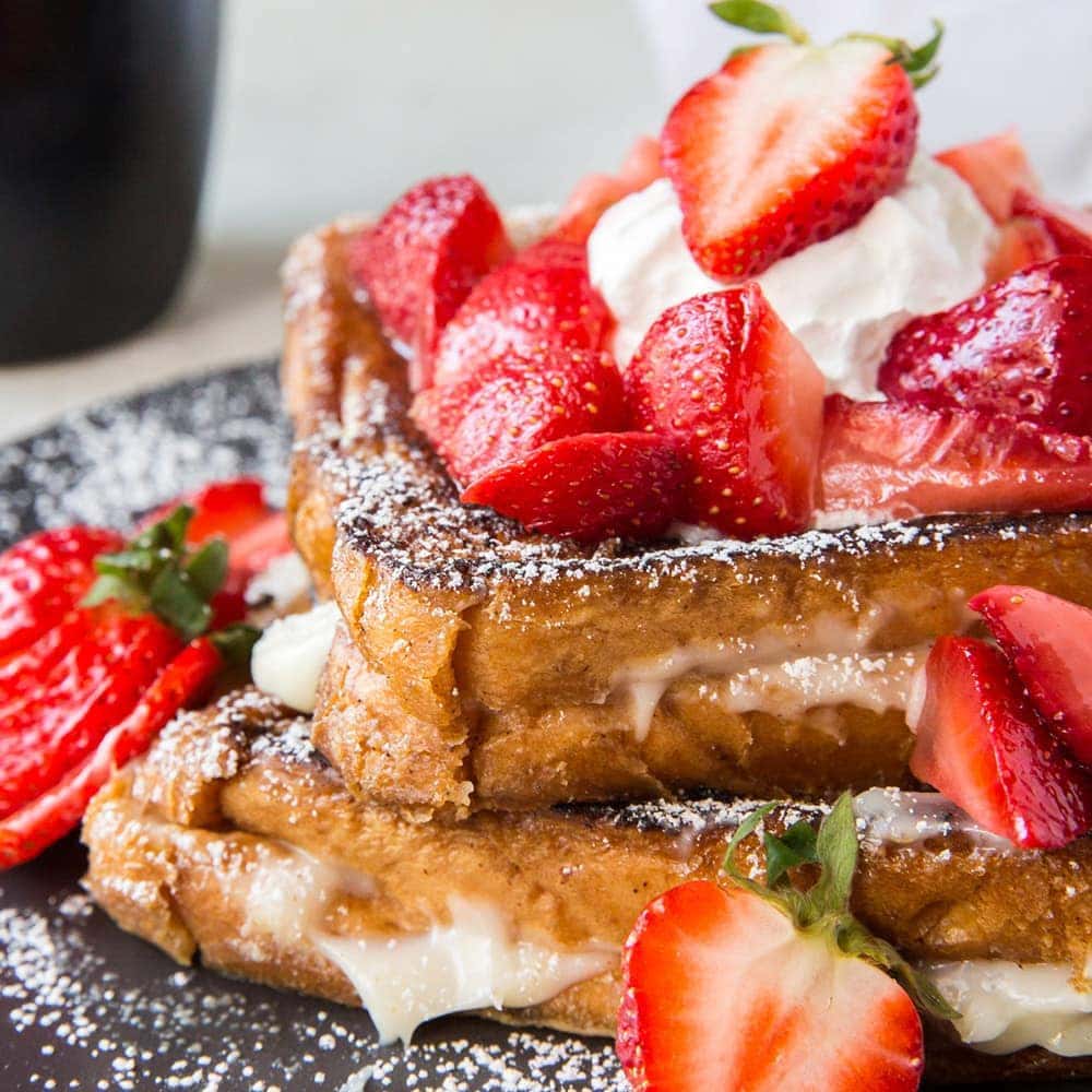 Plate of Cream Cheese Stuffed French Toast with Strawberries on top.