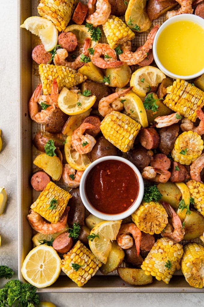 A large baking sheet with shrimp, corn, sausage and potatoes