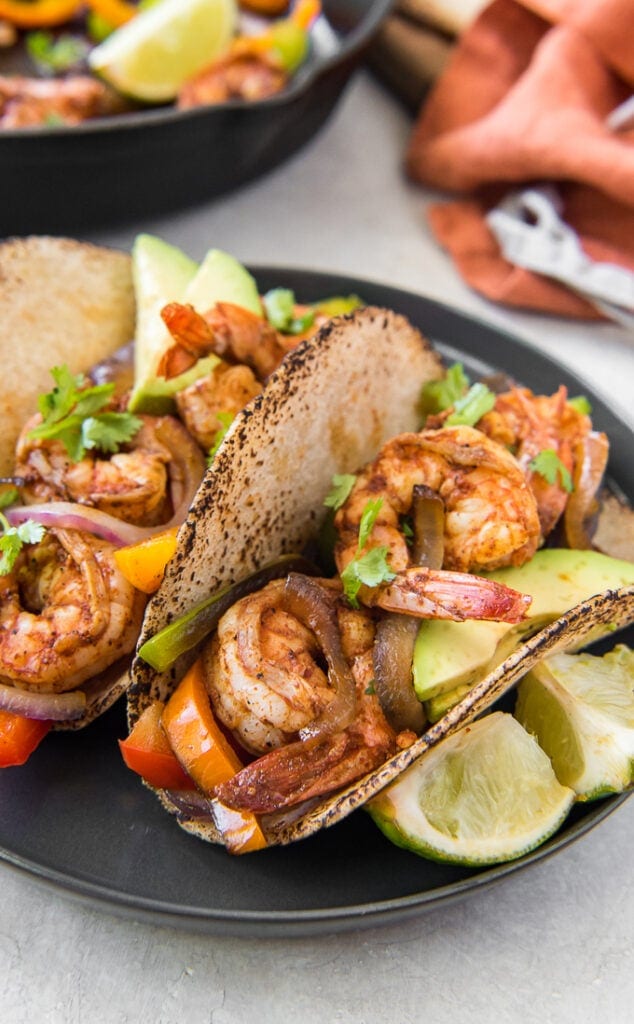 A close up image of shrimp fajitas with lime