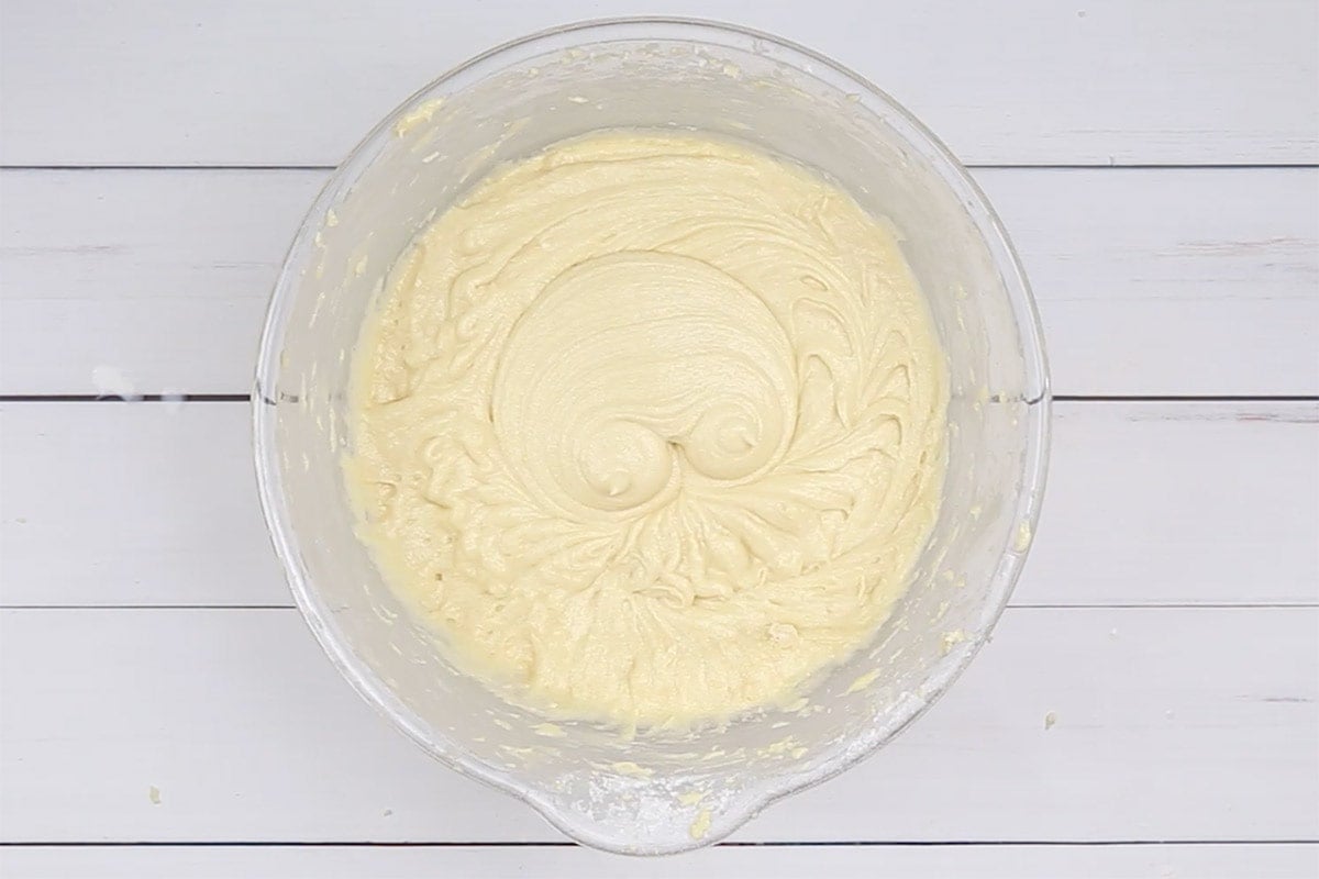 Mixed cake batter in a glass mixing bowl.