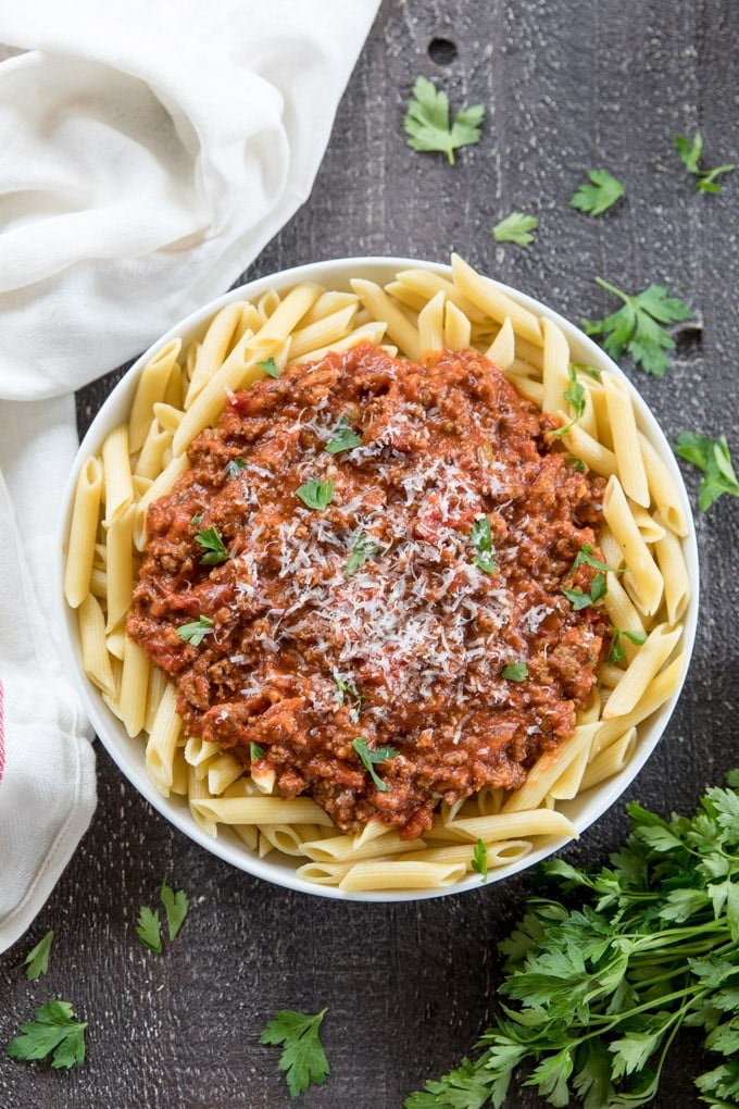 An overhead shot of a large bowl of penne pasta with meat sauce