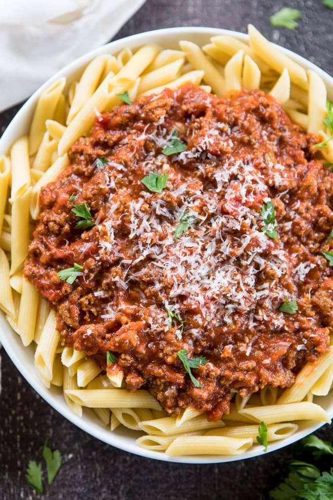 A close up, overhead image of penne pasta bolognese