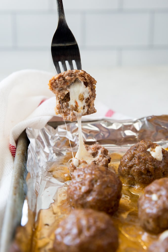 A foil covered tray of cheese stuffed meatballs