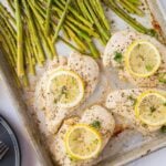 baking sheet with chicken breasts, lemon slices, asparagus social media image.