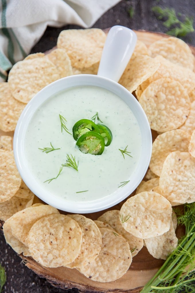 An overhead shot of jalapeno dill dip surrounded by tortilla chips.