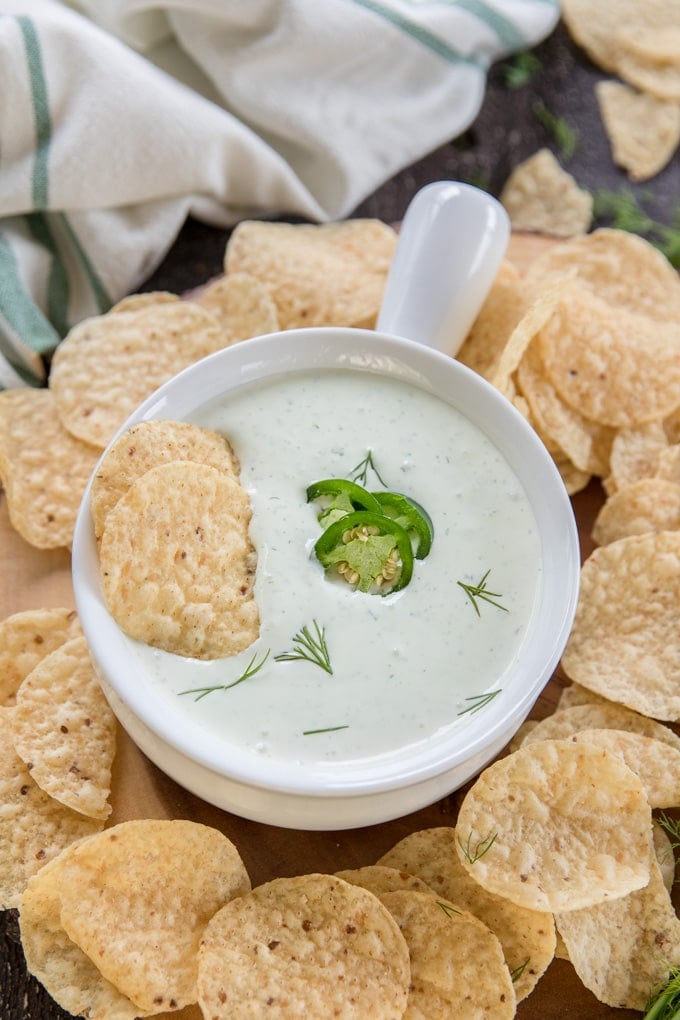Jalapeno Dill dip in a white bowl surrounded by tortilla chips