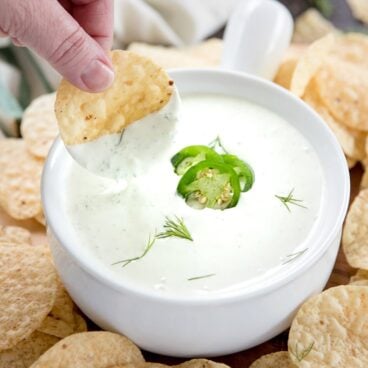 A bowl of Jalapeno Dill dip with a chip